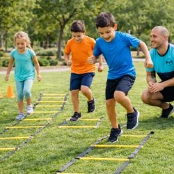 Progress - personal trainer with group of youth running agility ladders