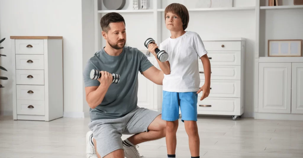 Father coaching young boy with dumbbells during an in-home workout session focused on strength and confidence building